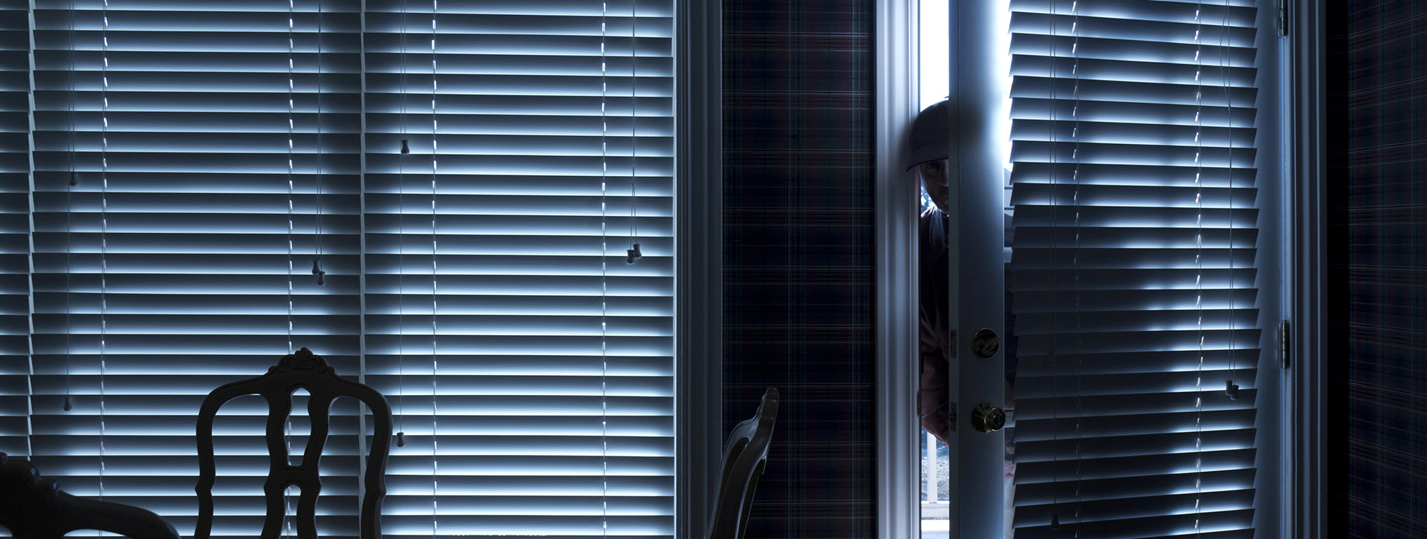 Man breaking into a house through the back door.